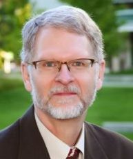 Dr. Davidi Lewerenz is pictured wearing a suit jacket, glasses and a tie. virtual health low vision