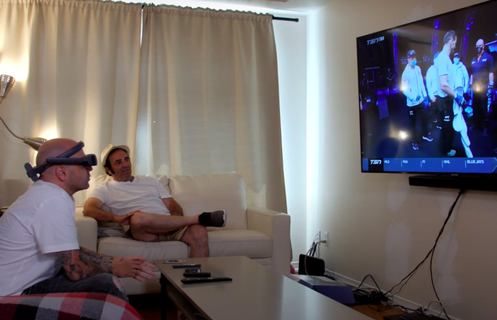 Anthony xem TV với sự hỗ trợ của eSight 4 và đang dùng tính năng phóng to.